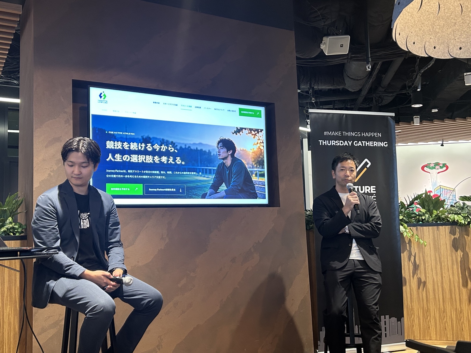 Sports Life Labのアスリート支援ページが映る会場で、マイクを持って話す住田優（右）と西村康平氏（左）